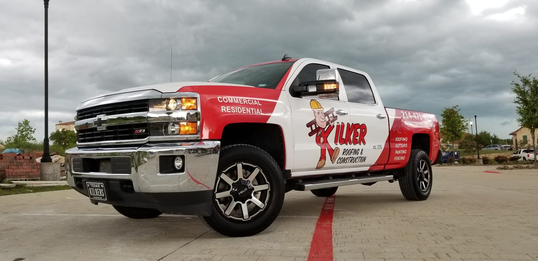 Kilker Roofing & Construction company truck under storm clouds